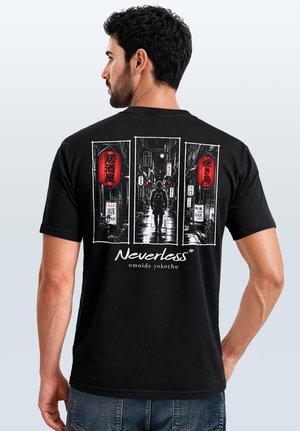 Man wearing black t-shirt with graphic of a person walking down a narrow, lantern-lit Japanese alley at night.