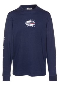 Mörkblå långärmad t-shirt med rund halsringning, med en vit broderad logotyp på bröstet och tryckt text längs ärmarna.