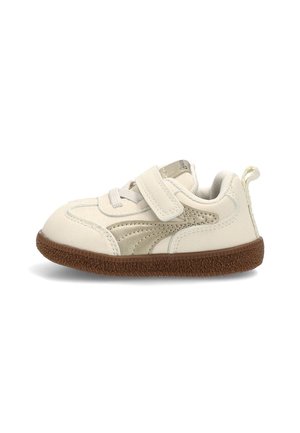 Zapatilla para niño pequeño color blanco roto con franja lateral beige, suela texturizada marrón, cierre de velcro y tira para tirar en el talón.