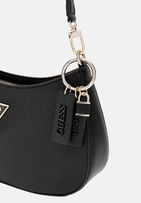 Borsa nera realizzata in materiale testurizzato, con un accento in hardware dorato, dettaglio ad anello e un charm con il nome del marchio.