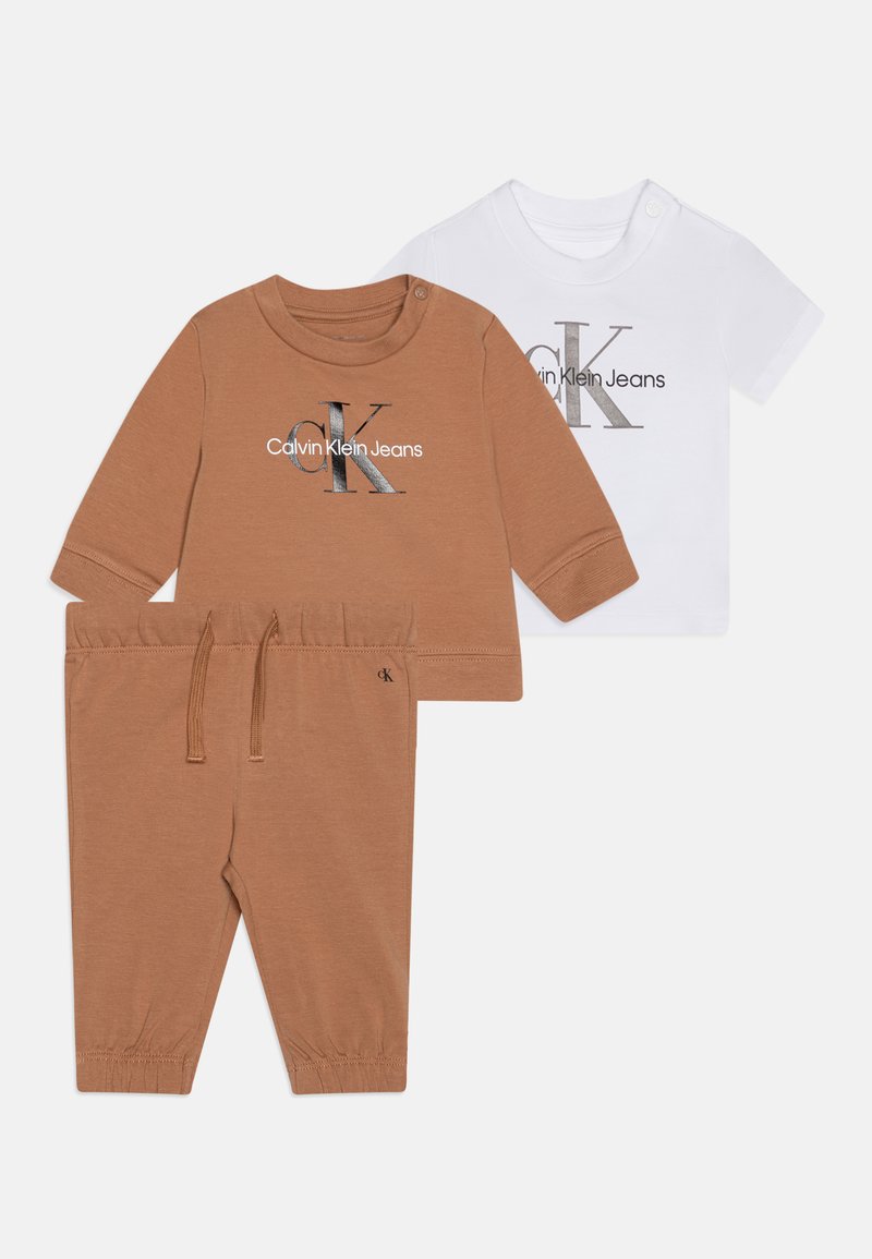 Conjunto para criança de duas peças: camiseta de mangas longas castanha com logotipo e calças correspondentes, camiseta de mangas curtas branca com gráfico. Tecido de algodão macio.