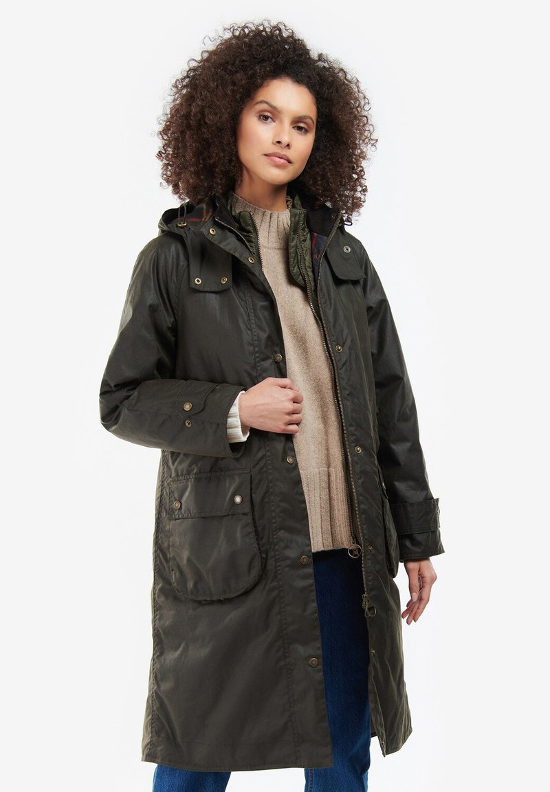Giacca impermeabile verde scuro con cappuccio, zip frontale, due grandi tasche frontali e dettagli con bottoni. Leggera, vestibilità casual.