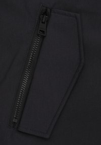 Melnas audumas ar rāvējslēdzēju, kas aprīkots ar izturīgu rāvējslēdzēju ar strukturētu apdari. Kabata ir leņķiskā formā, nodrošinot funkcionālu uzglabāšanu.