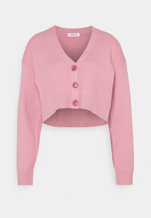 Růžový krátký cardigan s vertikálním žebrováním, výstřihem do V a třemi odpovídajícími knoflíky vpředu. Dlouhé rukávy s přiléhavými manžetami.