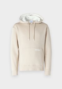 Felpa beige con cappuccio foderato di bianco, cordini e tasca frontale. Presenta un logo discreto sulla tasca. Realizzata in tessuto morbido.