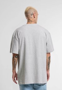 Gray cotton t-shirt with a relaxed fit, round neckline, and short sleeves, shown from the back. Features visible stitching details.