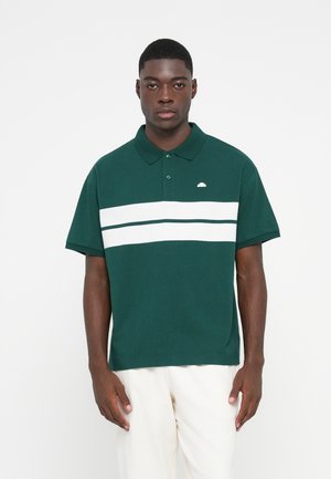 Polo verde hecho de algodón, con cuello, dos botones y rayas horizontales blancas en el pecho. Pequeño logo en el lado izquierdo.