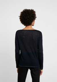 Langärmliges, marineblaues Strickoberteil mit lockerer Passform. Hat einen weiten Ausschnitt und eine strukturierte Strickqualität, mit kontrastierenden seitlichen Akzenten.