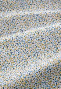 Tessuto di cotone con motivo a foglie ricorrenti in blu, giallo e grigio su sfondo bianco, con una texture liscia e una sottile lucentezza.