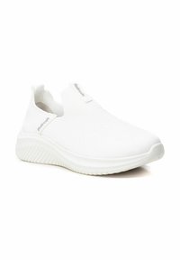 Zapatilla blanca sin cordones hecha de malla transpirable, con una superficie texturizada, suela acolchada y detalle del logo en el costado.
