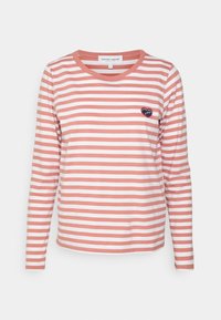 Langärmliges T-Shirt mit korallen- und weißen Streifen, rundem Halsausschnitt und kleinem marineblauen Herz-Logo auf der linken Brust. Aus Baumwollmaterial.