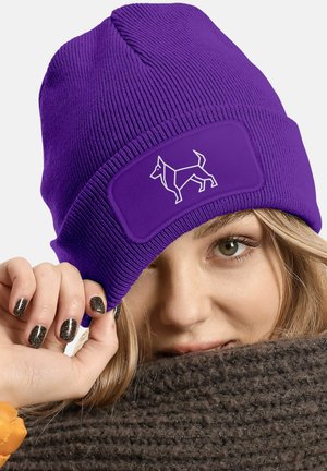 Purple knitted beanie with ribbed design and a woven patch featuring a white outlined dog graphic. Soft texture and close-fit shape.