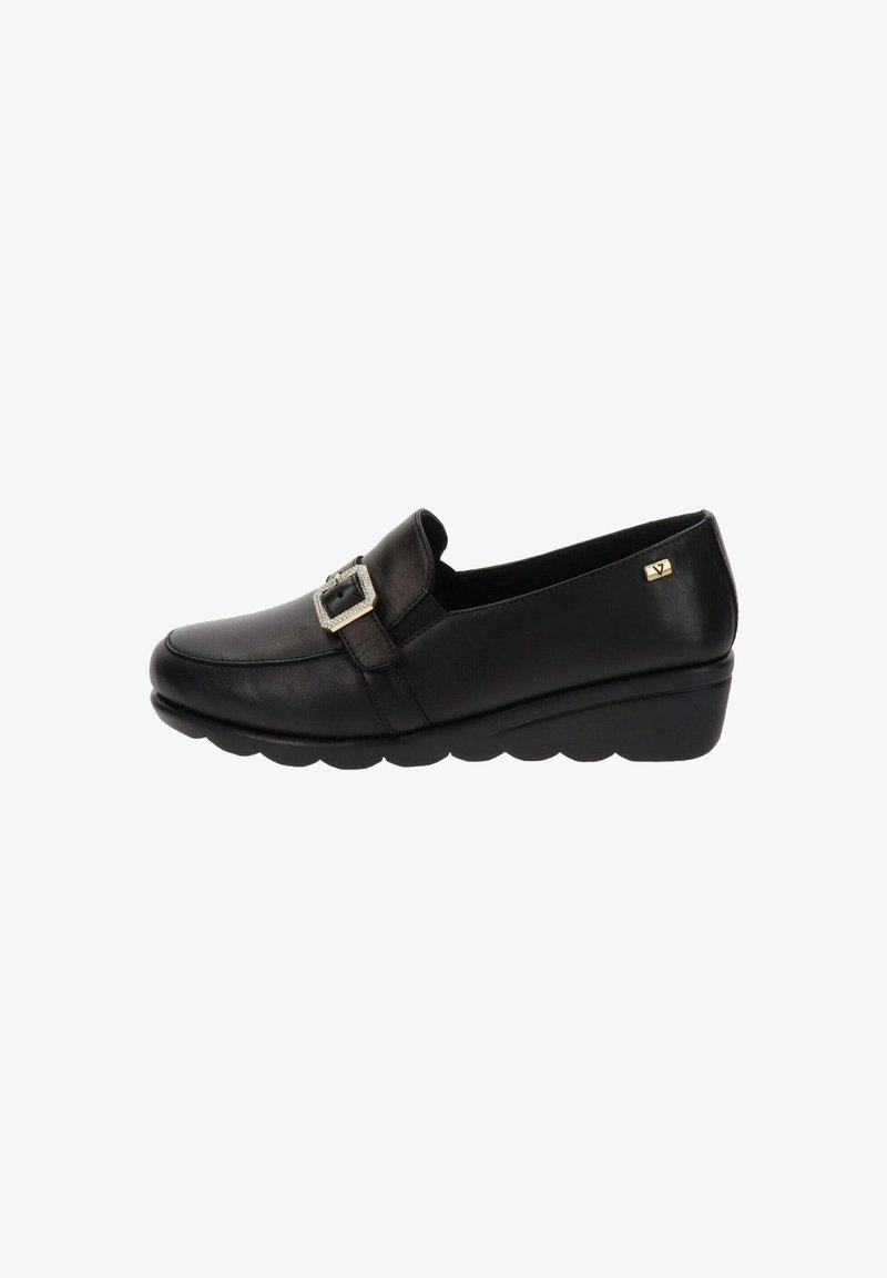 Chaussure noire en cuir à enfiler, dotée d'une boucle en argent décorative, d'un bout arrondi et d'une semelle en wedge basse avec un fond texturé.