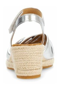 Silberne Leder-Espadrillesandalen mit einem geflochtenen Jute-Absatz und Knö ankle strap, die eine abgerundete Form und eine glatte Textur aufweisen.