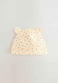 Chapeau pour bébé jaune à côtes avec des motifs floraux roses, proposant des oreilles arrondies et un revers. Texture de tissu douce sur l'ensemble.