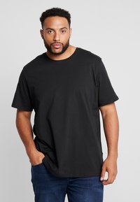 Zwarte katoenen t-shirt met een ronde hals, korte mouwen en een relaxed fit. De stof heeft een gladde textuur en een minimalistisch ontwerp.