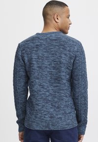 Pulover tricotat de culoare bleu marin, cu un design texturat, manșete și tiv din material ribbed. Vederea din spate arată un guler rotund și panouri laterale detaliate.