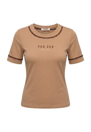 T-shirt beige a maniche corte con rifinitura decorativa marrone su maniche e scollo, con testo "YES ZEE Natural Feeling" sul petto.