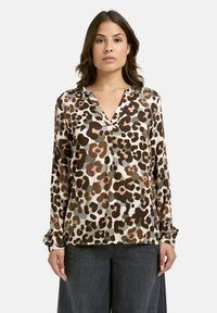 Bluse im Leopardenmuster aus weichem Stoff, mit V-Ausschnitt, langen �Ärmeln und in lockerer Passform in den Farben Braun, Grün und Creme.