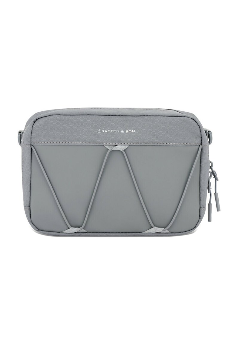 Borsa da viaggio grigia realizzata in tessuto texturizzato; chiusura a zip, dettagli elastici frontali e logo visibile nella parte superiore. Forma rettangolare compatta.