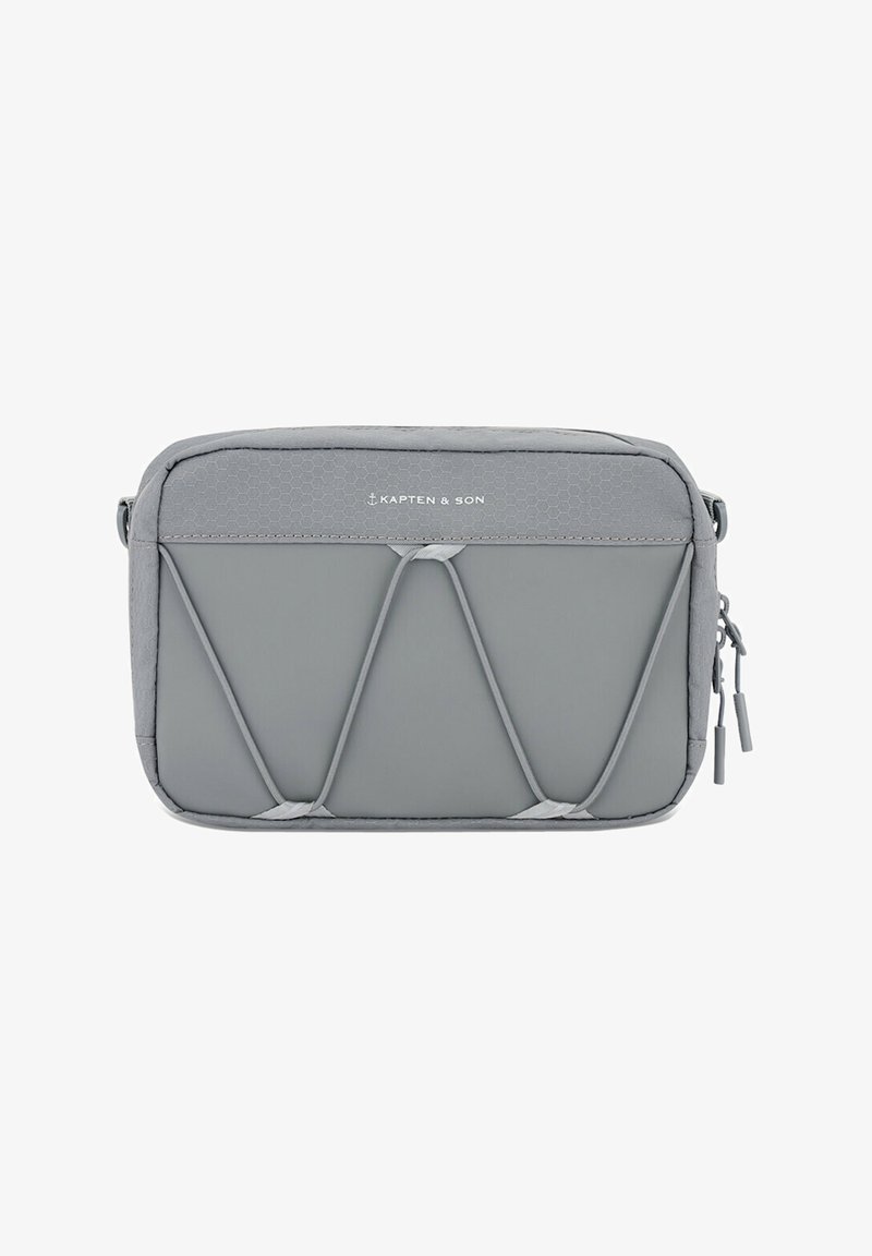 Grijze reistas van structuurstof; ritssluiting, elastische details aan de voorkant en logo zichtbaar op de bovenkant. Compacte rechthoekige vorm.