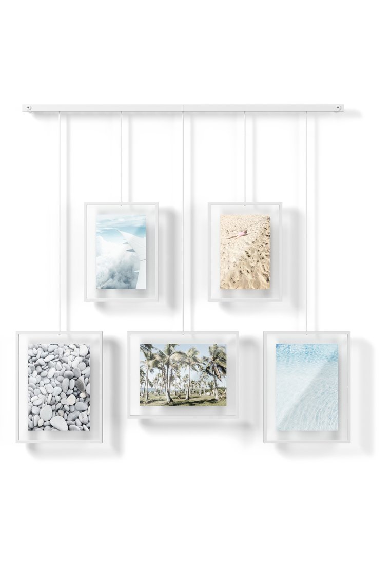 Fünf hängende Bilderrahmen präsentieren Bilder von Wolken, einem Sandstrand, Kieseln, Palmen und Wasser, alles auf einem minimalistischen weißen Hintergrund.