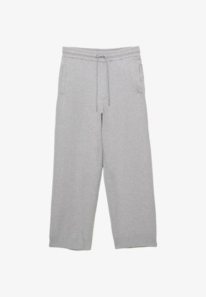 Pantaloni della tuta grigio chiaro, larghi e realizzati in un morbido misto cotone, con un elastico in vita e cordini regolabili, oltre a tasche laterali.