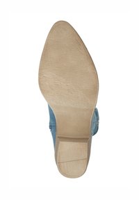 Zapato azul claro con un upper liso y punta afilada, que cuenta con una suela de goma beige con un patrón de agarre texturizado.