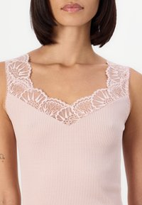 Ribbed pink tank top with a V-neckline, featuring delicate lace trim along the edges. Smooth texture and fitted design.
