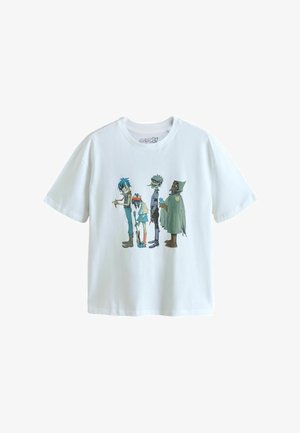 Fehér póló, amelyen négy animált karakter áll oldalt nézve, mindegyik jellegzetes, színes és stilizált ruházattal és kiegészítőkkel.