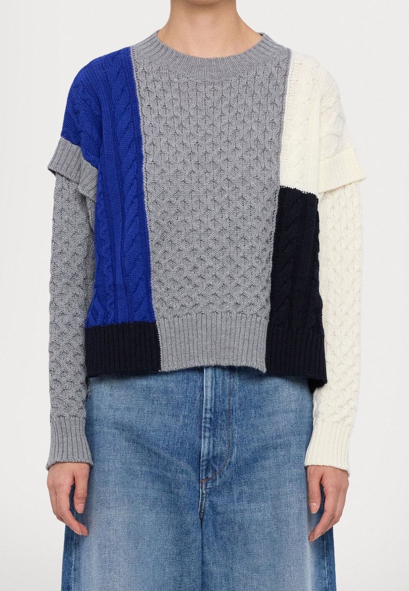 Gebreide trui met een boxy ontwerp en een mix van grijze, blauwe, marineblauwe en witte panelen; kabelbrei-textuur; geribde mouwen en zoom.