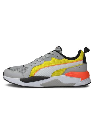 Baskets de sport grises, jaunes et orange avec panneaux en mesh, semelle blanche, détails noirs et languette au talon, vues de profil.