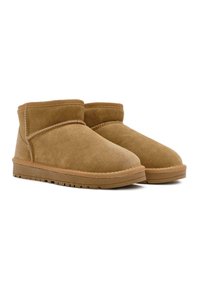 Tanfarbene Wildlederstiefeletten mit einer abgerundeten Zehenpartie, gesteppten Details und einer Gummisohle mit strukturiertem Profil für besseren Halt.