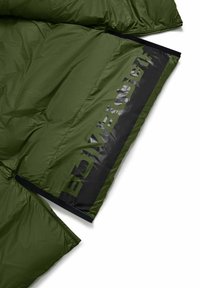 Groene pufferjas met een glanzende textuur en een groot zwart logo op de borst. Beschikt over een ritssluiting en elastische manchetten.