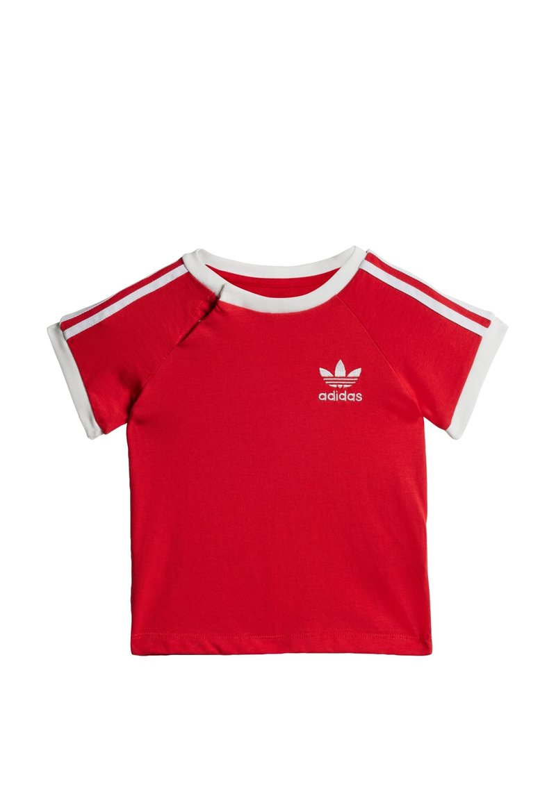 Červené bavlnené tričko s krátkymi rukávmi, bielym okrúhlym výstrihom a tromi pruhmi na každom pleci. Obsahuje vyšitý logotyp adidas na hrudi.
