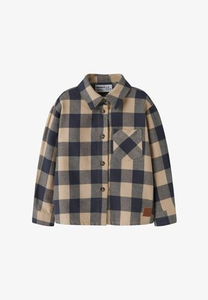 Skjorte med knapper og lange ærmer med beige og mørkeblå stort ternet mønster og en forlommelomme på venstre side af brystet.