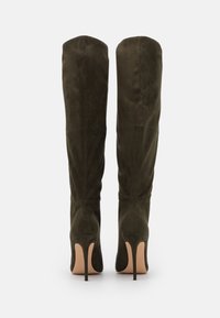 Knee-high, olivově zelené semišové boty s špičatými špičkami, vysokými stiletto podpatky a bezproblémovým designem, vybavené jemným švem na panelech.