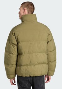 Olīvzaļš pūkains džemperis ar augstu apkakli, quilted dizainu un gludu tekstūru. Izceļas ar piemērotu siluetu un elastīgām piedurknēm.