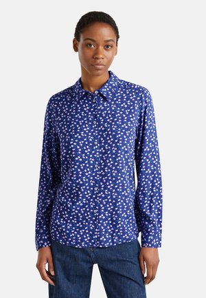 Camicia blu a maniche lunghe con design a colletto, caratterizzata da un piccolo motivo floreale in rosa e bianco. I bottoni si trovano sul davanti.