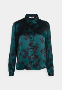 Grüne satinierte Bluse mit langen Ärmeln, Knopfleiste, schwarzem Blumenmuster, spitzem Kragen und weicher Textur.
