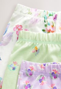 Tres pares de leggings de algodón elástico: blanco con estampado floral multicolor, verde claro con flores pequeñas y lila claro con detalles florales.