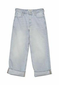 Jean en denim bleu clair avec une coupe décontractée, comportant des poches latérales, un ourlet roulé et une texture légèrement délavée. Étiquette de la marque "AWARE" sur la taille.