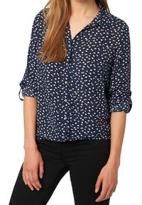 Navy button-up shirt with a floral pattern in pink and white. Long sleeves rolled up, made of a lightweight fabric with a smooth texture.