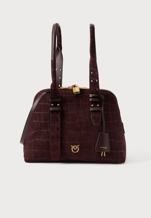 Tmavohnedá semišová kabelka s krokodílou textúrou, dvojitými uchami, zlatým zámkom a dekoratívnym zlatým emblémom na prednej strane.