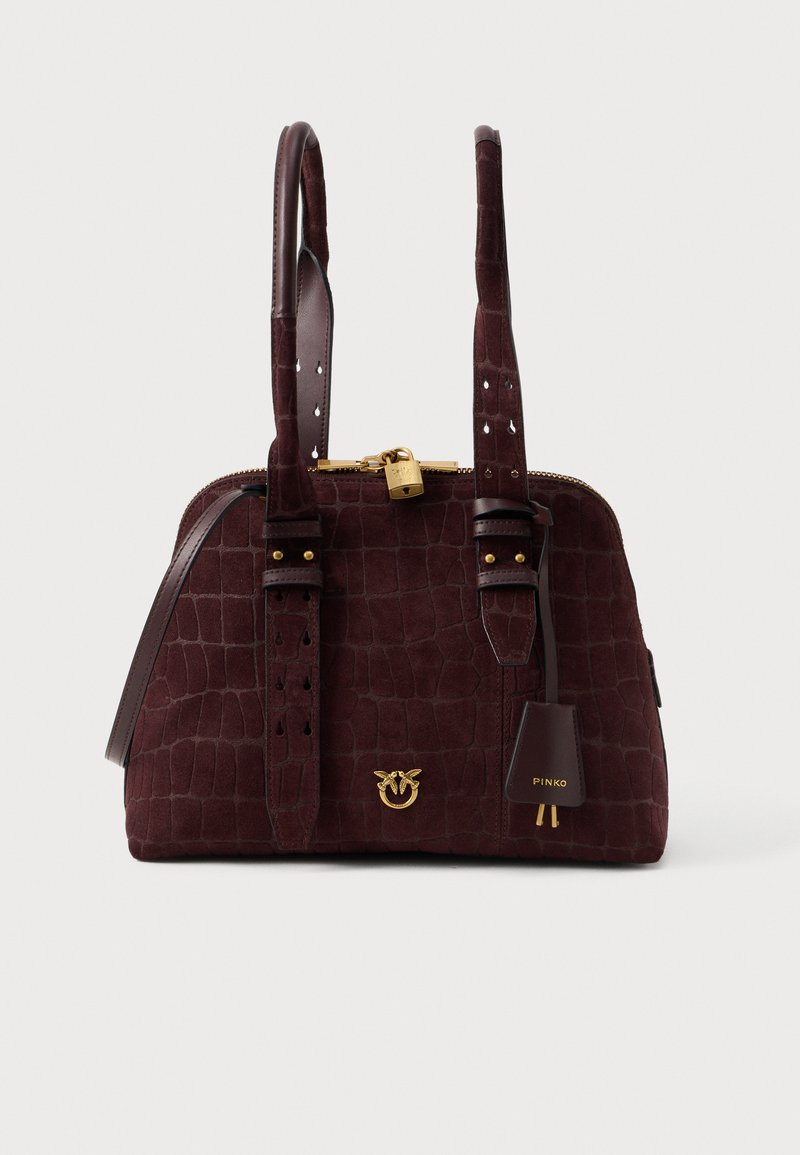 Tmavohnedá semišová kabelka s krokodílou textúrou, dvojitými uchami, zlatým zámkom a dekoratívnym zlatým emblémom na prednej strane.