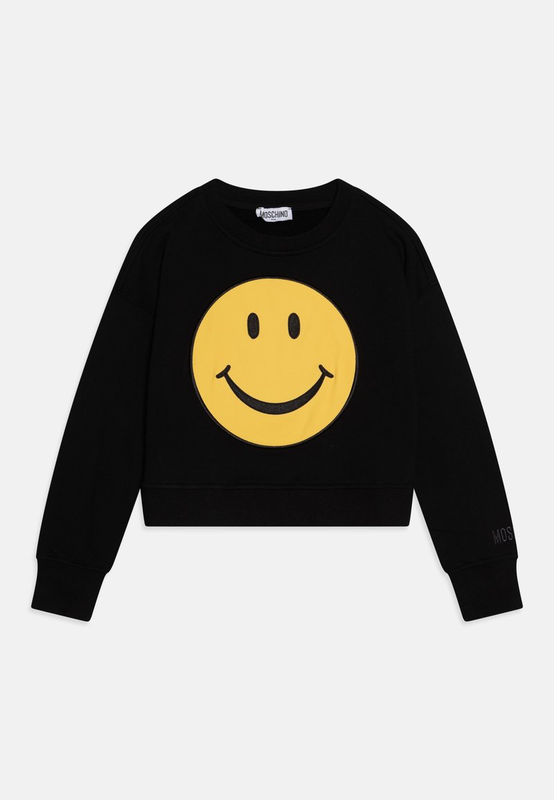 Svart kort sweatshirt i mjukt tyg med en stor gul smiley-ansikte grafik på framsidan och liten varumärkestext på ärmen.
