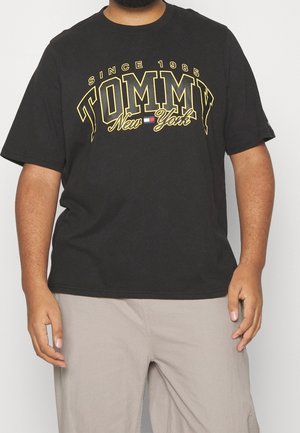 Czarna bawełniana koszulka z żółtym nadrukiem "TOMMY New York" i "SINCE 1985." Krótkie rękawy i okrągły dekolt.