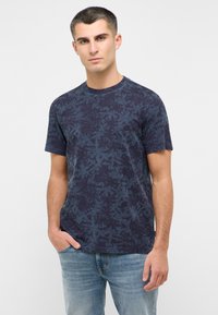 T-shirt z krótkim rękawem i okrągłym dekoltem w granatowym kolorze, pokryty teksturowanym wzorem liści palmowych. Wykonany z miękkiej dzianiny bawełnianej, o lekko dopasowanym kroju.