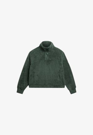 Groene fleece pullover met een hoge kraag, een knopenlijst aan de voorkant en twee ritssluitingen aan de zijkanten. Zachte textuur en een relaxte pasvorm.