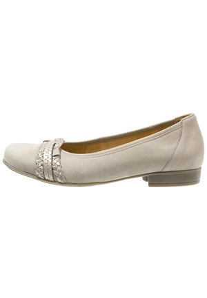 Lichtbeige dames platte schoen met lage hak en gevlochten sierbanden aan de voorkant, zijaanzicht.